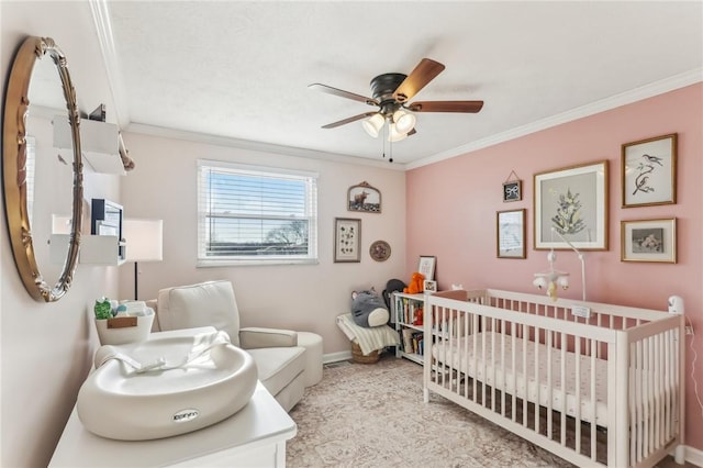 bedroom featuring ceiling fan, a crib, and ornamental molding