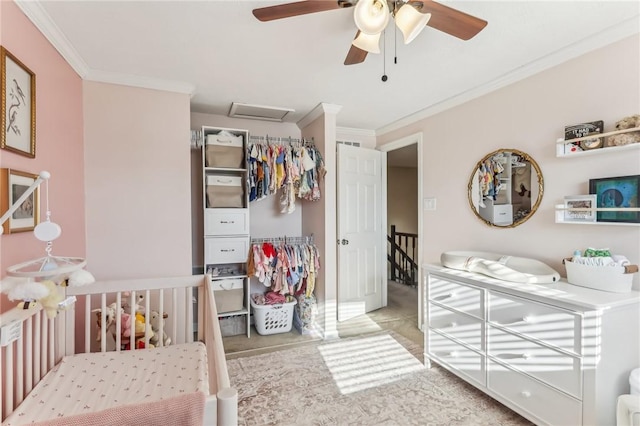 bedroom with ceiling fan, light colored carpet, a crib, and crown molding