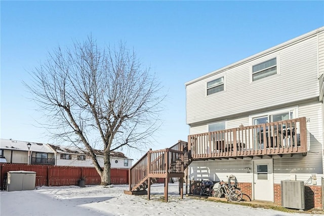 snow covered house featuring central AC unit