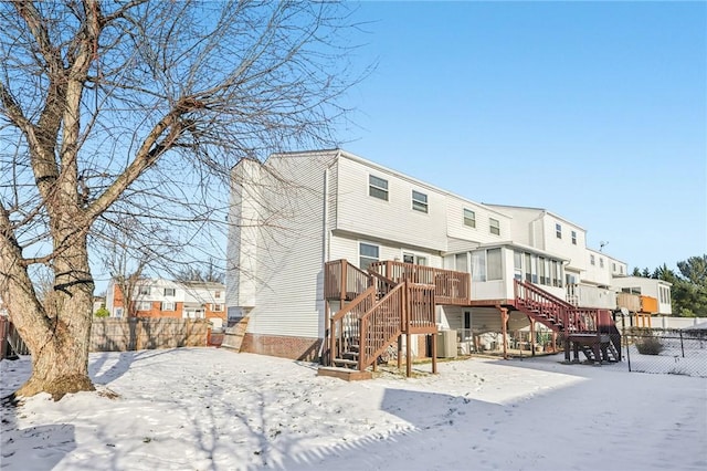 snow covered property featuring central AC