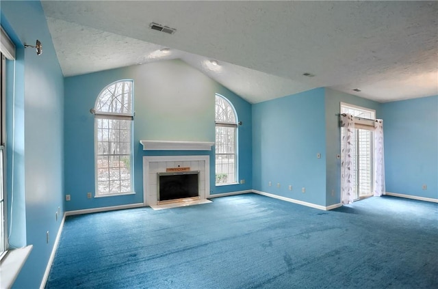 unfurnished living room featuring a textured ceiling, carpet flooring, a fireplace, and vaulted ceiling