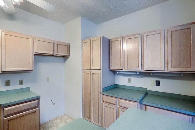 kitchen featuring ceiling fan, light brown cabinets, and a textured ceiling