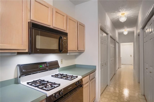 kitchen featuring a notable chandelier, light brown cabinetry, and gas range gas stove