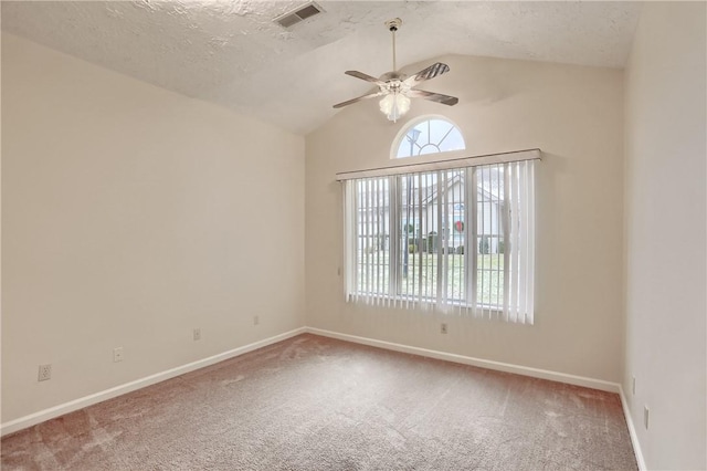 carpeted empty room featuring a textured ceiling, ceiling fan, and vaulted ceiling