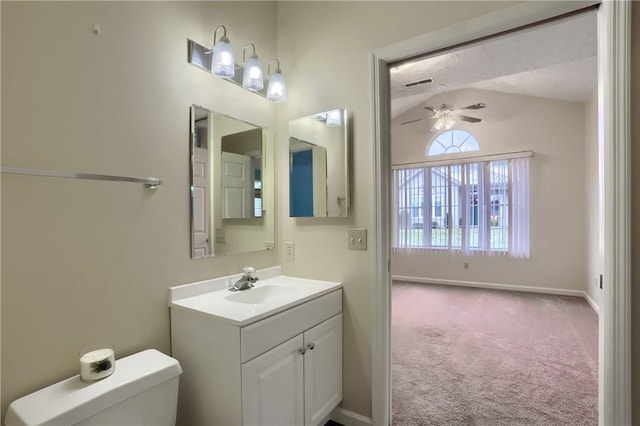 bathroom with ceiling fan, toilet, vanity, and vaulted ceiling