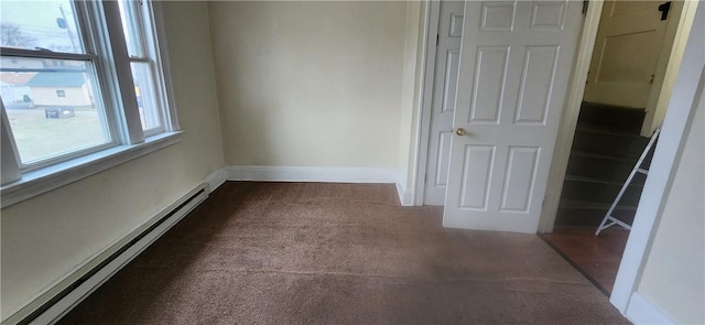 unfurnished room with carpet floors and a baseboard heating unit