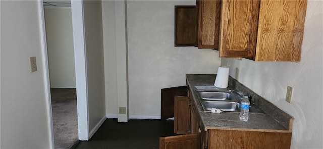 kitchen with dark colored carpet and sink