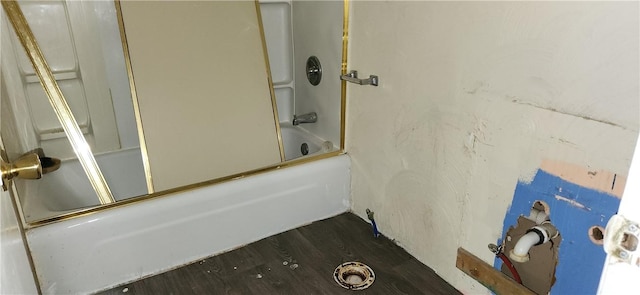 bathroom with wood-type flooring and bath / shower combo with glass door