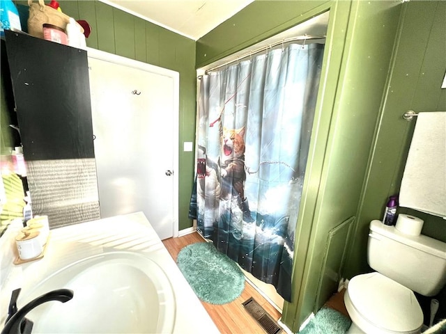 bathroom with a shower with curtain, hardwood / wood-style flooring, toilet, and sink