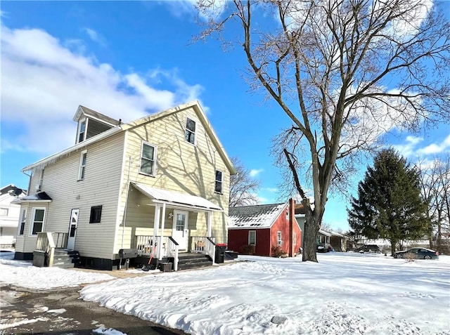 view of snow covered back of property