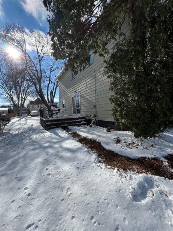 view of snowy exterior with a deck