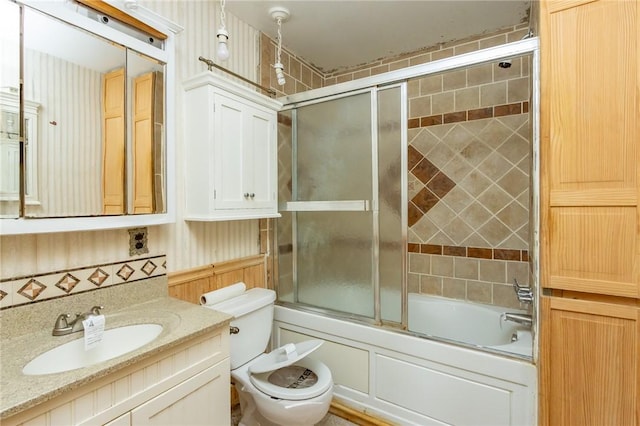 full bathroom featuring vanity, toilet, and shower / bath combination with glass door