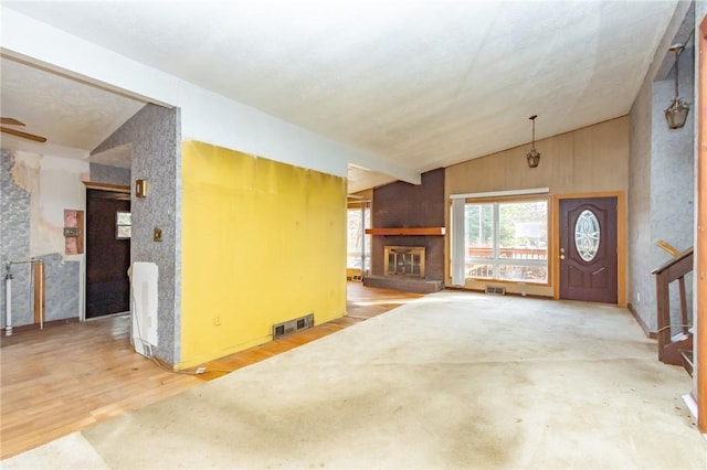 unfurnished living room featuring hardwood / wood-style flooring and vaulted ceiling