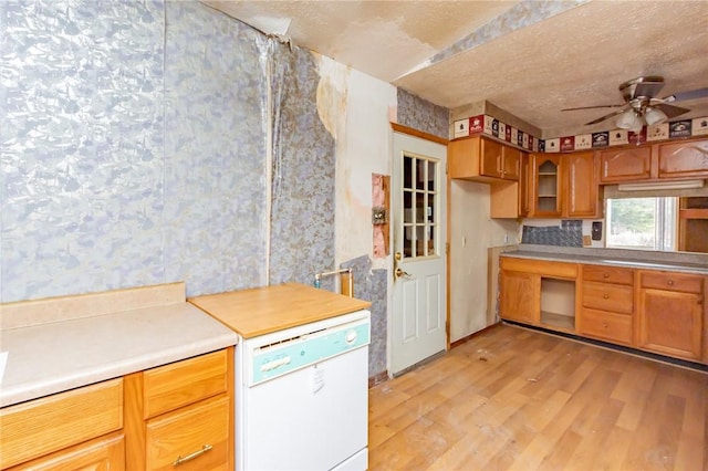 kitchen with light wood-type flooring, white dishwasher, and ceiling fan