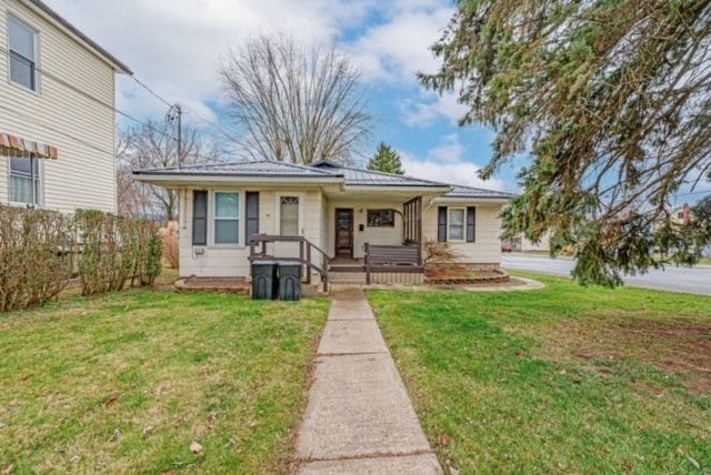 view of front of property featuring covered porch and a front yard