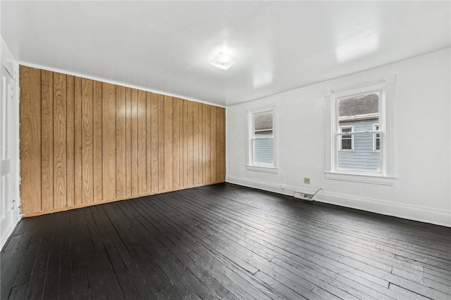 empty room with wood walls and dark wood-type flooring