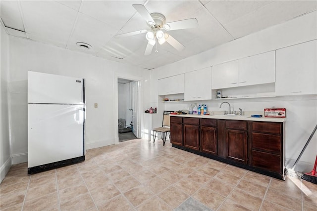 kitchen with white cabinets, white refrigerator, sink, ceiling fan, and dark brown cabinets