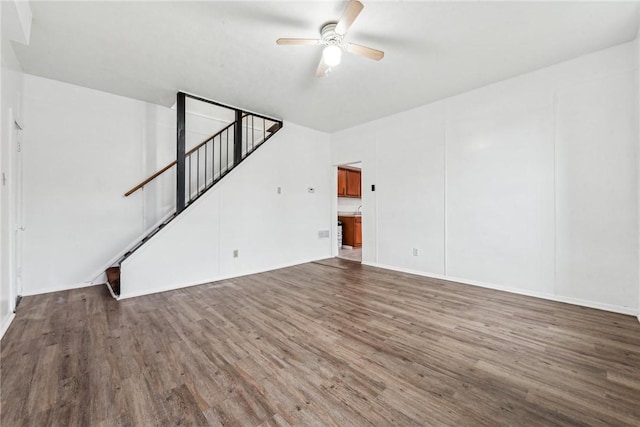 unfurnished living room with ceiling fan and dark wood-type flooring