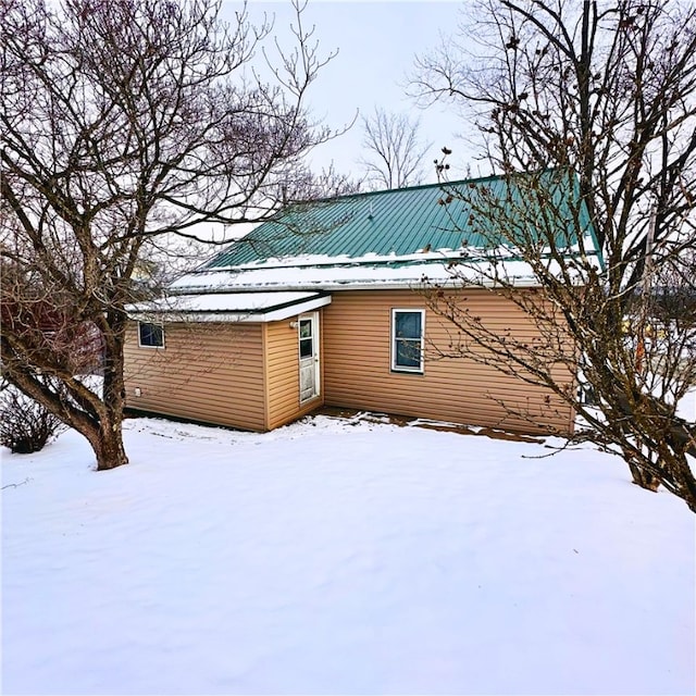 view of snow covered back of property