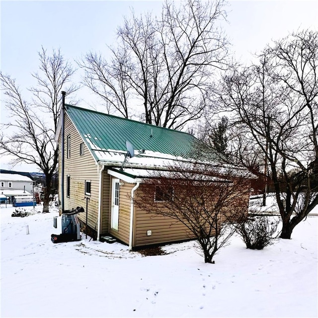 view of snow covered back of property