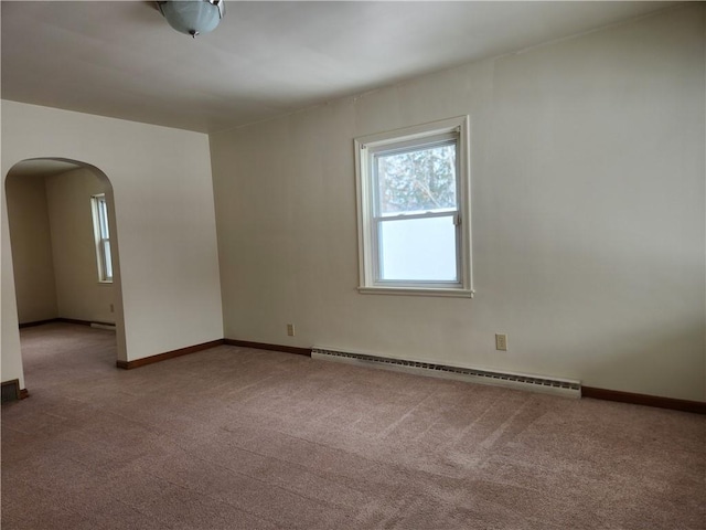 empty room with light colored carpet and a baseboard radiator