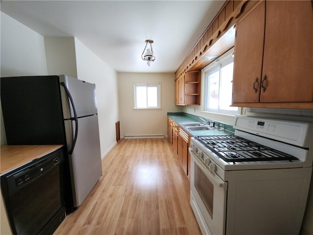 kitchen featuring light wood-type flooring, white range with gas cooktop, sink, dishwasher, and hanging light fixtures