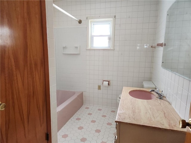 bathroom with tile patterned flooring, decorative backsplash, vanity, tile walls, and tiled shower / bath