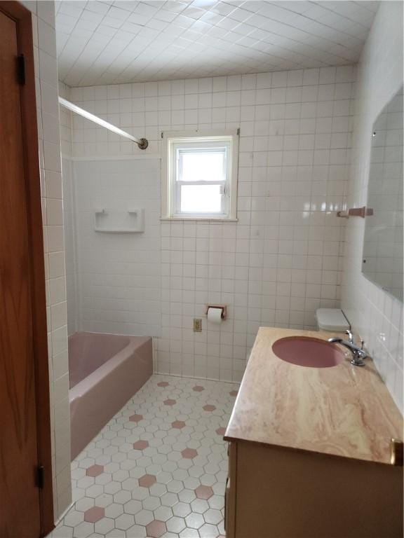 bathroom featuring vanity, tile patterned floors, tile walls, and tub / shower combination