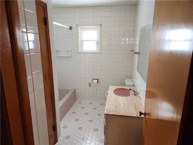 bathroom with tile patterned floors, vanity, and tile walls