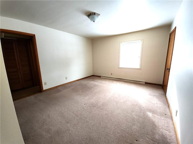 empty room featuring light colored carpet and a baseboard radiator