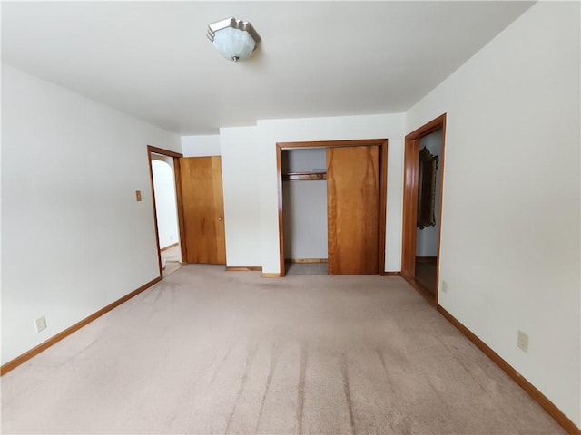 unfurnished bedroom featuring light colored carpet and a closet