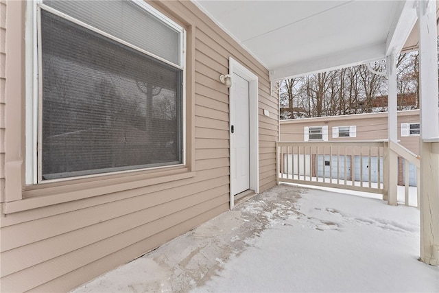 snow covered patio with a porch