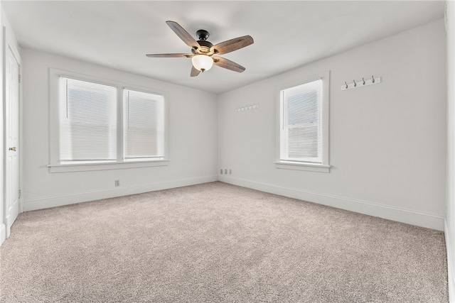 carpeted spare room with ceiling fan