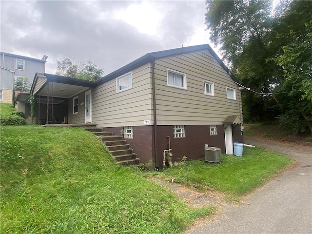 view of property exterior with a yard and central AC