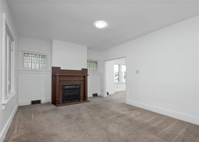 unfurnished living room featuring light carpet and a fireplace