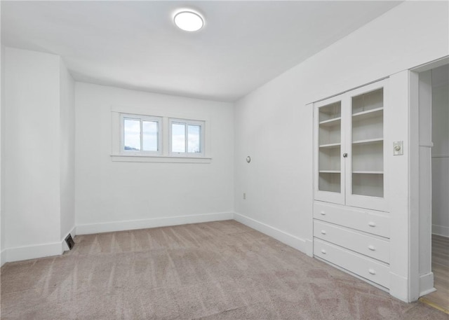 spare room featuring light colored carpet