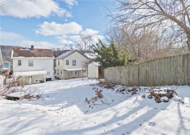 yard layered in snow with a storage unit