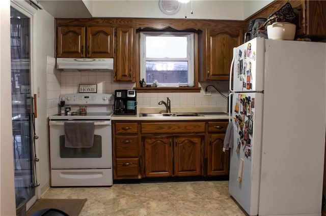 kitchen featuring white appliances, decorative backsplash, and sink