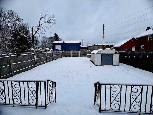 yard layered in snow featuring a storage shed