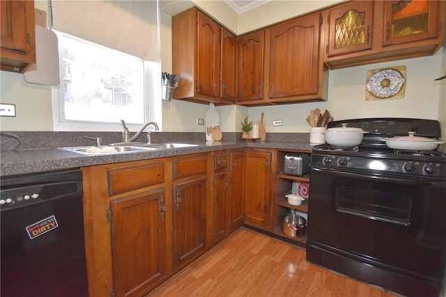 kitchen featuring sink, light hardwood / wood-style flooring, ornamental molding, and black appliances