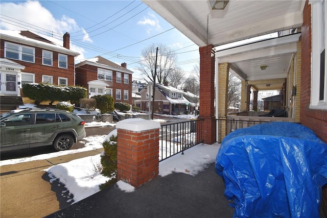 snow covered patio featuring a porch