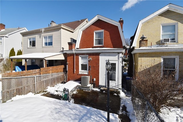 snow covered back of property with cooling unit