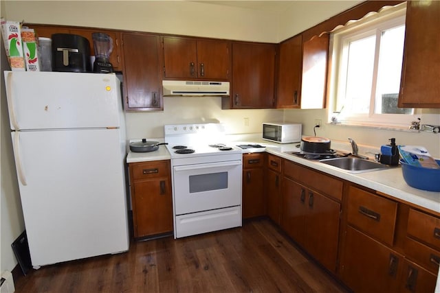 kitchen with sink, white appliances, dark wood-type flooring, and a baseboard heating unit