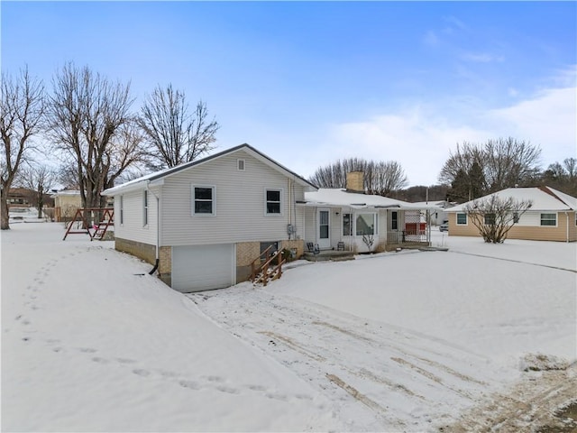 snow covered property with a garage