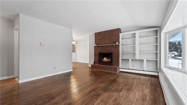 unfurnished living room featuring a brick fireplace, dark hardwood / wood-style floors, and a baseboard heating unit