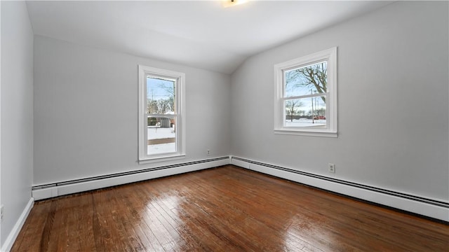 spare room featuring hardwood / wood-style floors, baseboard heating, and a wealth of natural light