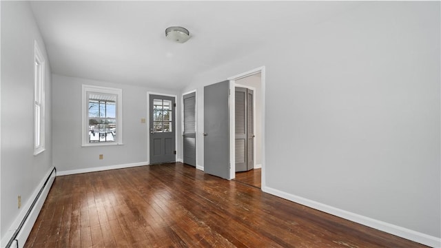 spare room featuring a baseboard radiator and dark hardwood / wood-style floors