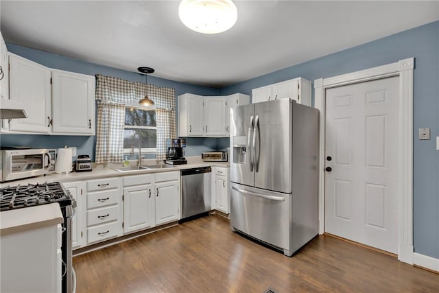 kitchen with decorative light fixtures, white cabinetry, sink, and appliances with stainless steel finishes