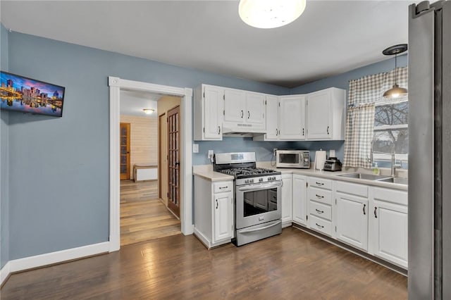 kitchen with white cabinets, stainless steel appliances, and decorative light fixtures