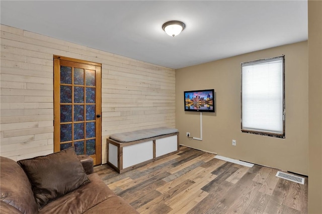 interior space featuring hardwood / wood-style floors, plenty of natural light, and wooden walls